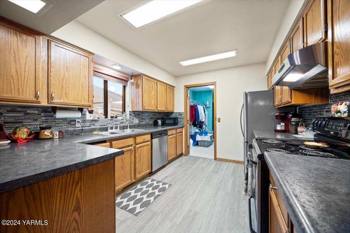 1802 Young Street Grandview, WA 98930 - Photo 20 of 31 a kitchen with stainless steel appliances granite countertop a stove a sink dishwasher and a refrigerator