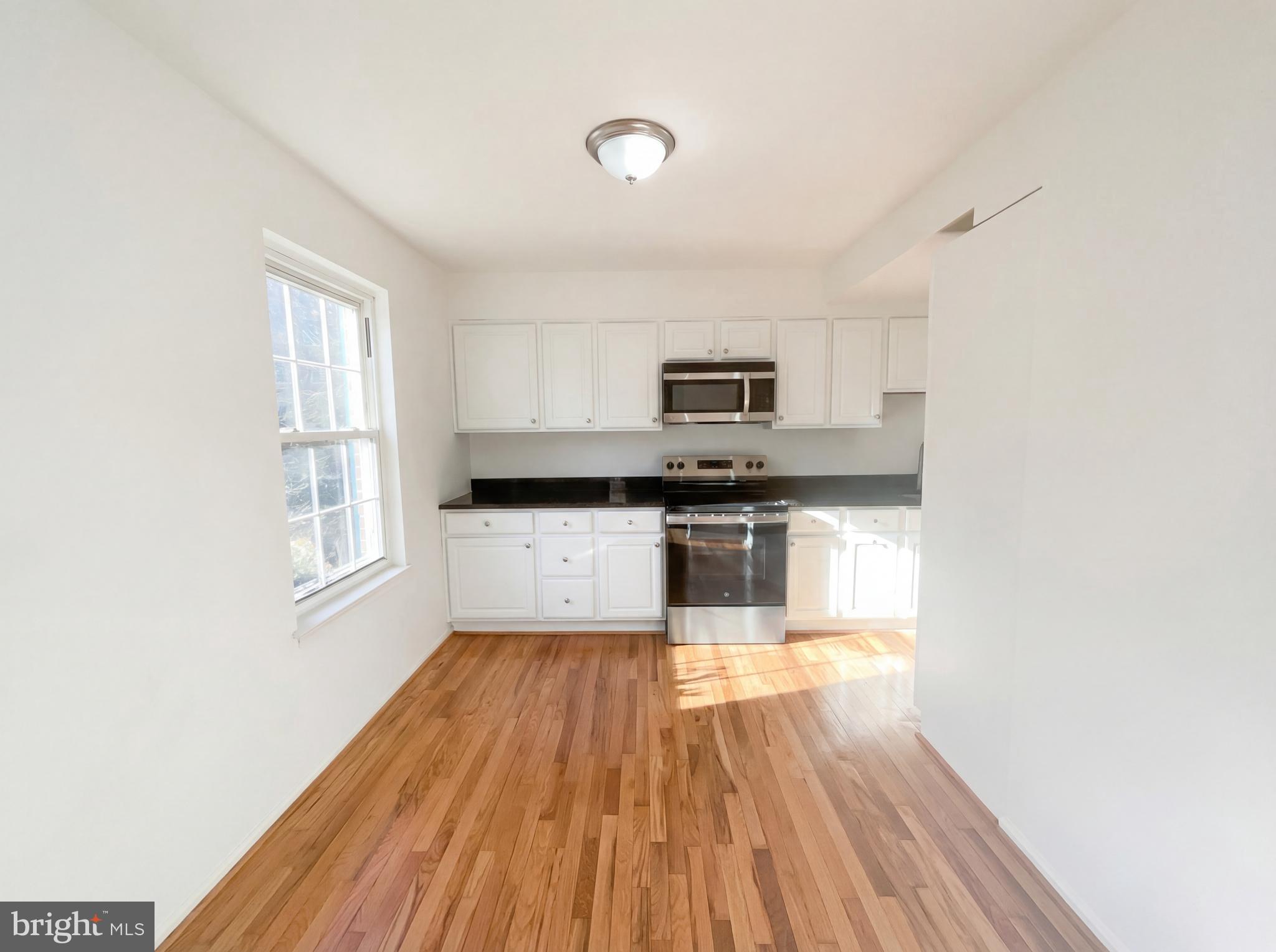 6352 Shaundale Drive Springfield, VA 22152 - Photo 13 of 50 a kitchen with wooden floors and white appliances