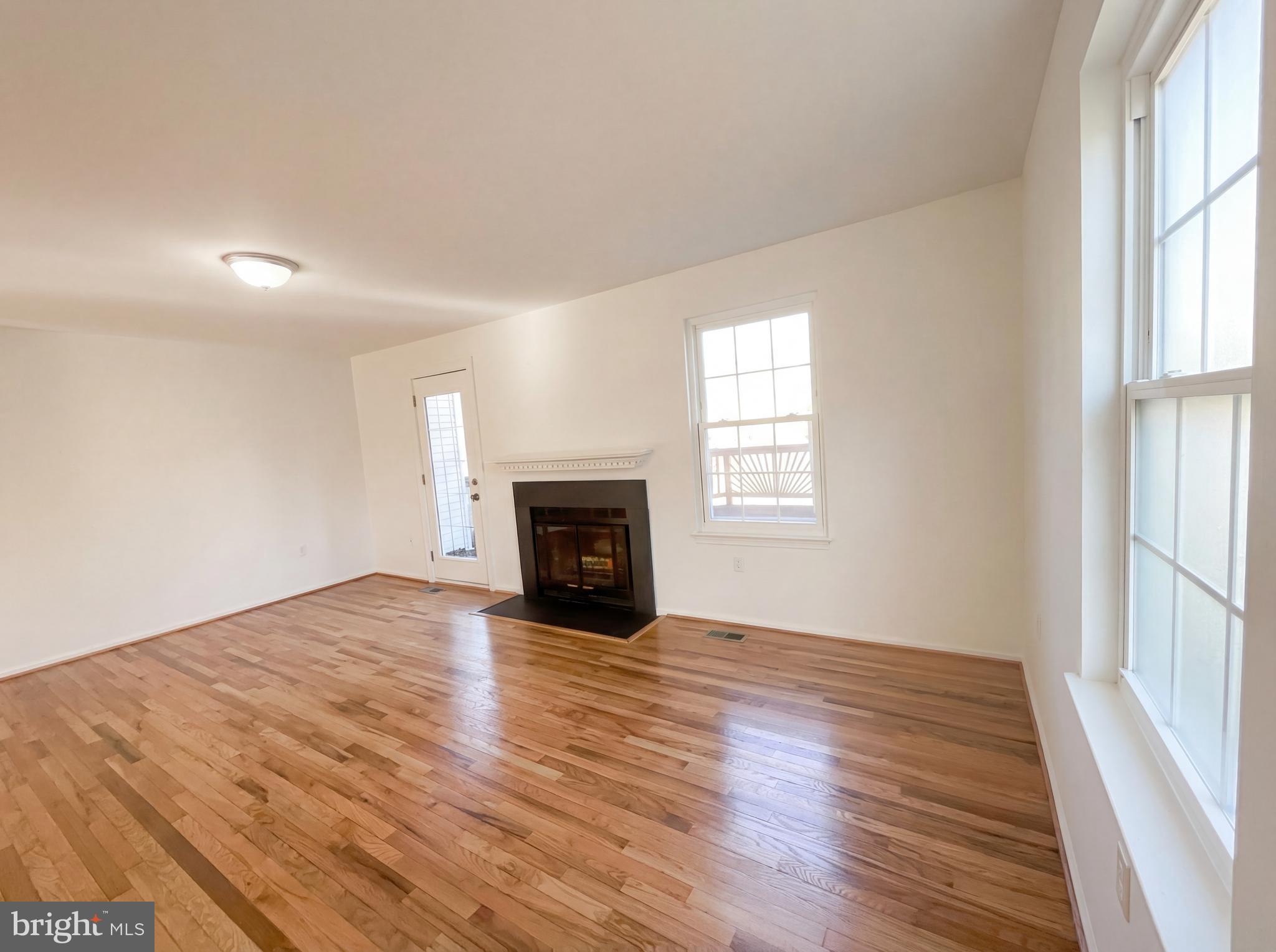 6352 Shaundale Drive Springfield, VA 22152 - Photo 16 of 50 an empty room with wooden floor fireplace and windows