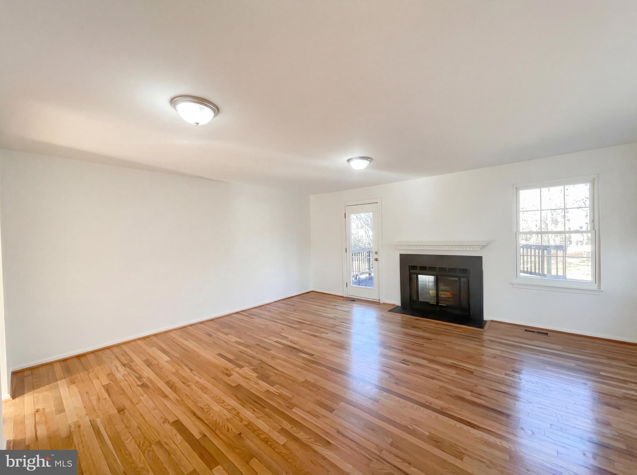 6352 Shaundale Drive Springfield, VA 22152 - Photo 17 of 50 an empty room with wooden floor fireplace and windows