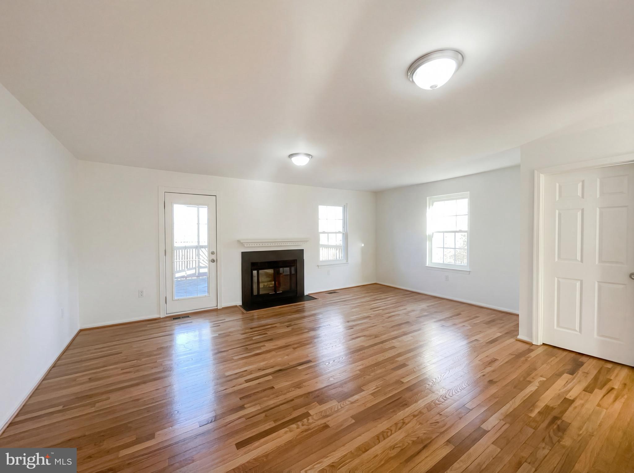 6352 Shaundale Drive Springfield, VA 22152 - Photo 4 of 50 an empty room with wooden floor fireplace and windows