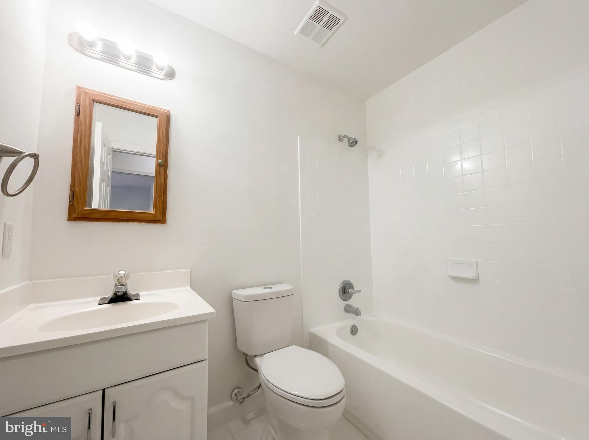 6352 Shaundale Drive Springfield, VA 22152 - Photo 41 of 50 a bathroom with a toilet a sink a mirror and a bathtub