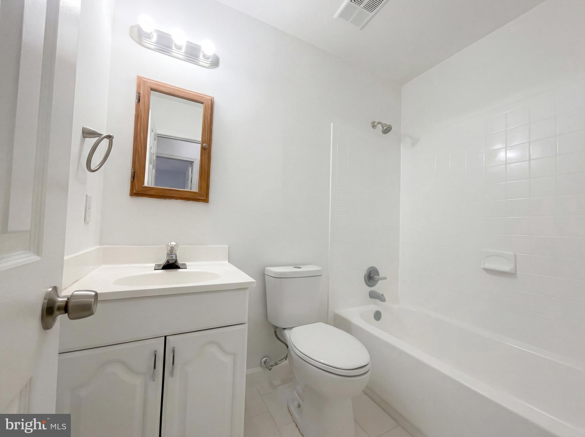 6352 Shaundale Drive Springfield, VA 22152 - Photo 43 of 50 a bathroom with a toilet a sink a mirror and a bathtub