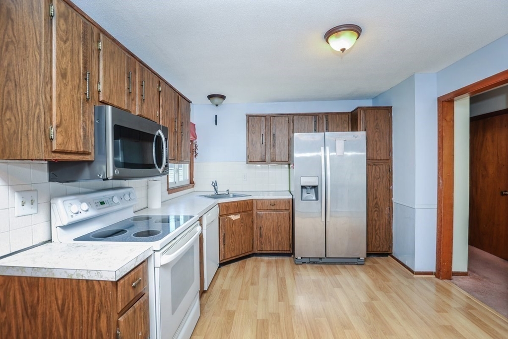 19 Longbow Road Danvers, MA 01923 - Photo 17 of 39 a kitchen with stainless steel appliances granite countertop a refrigerator stove and sink
