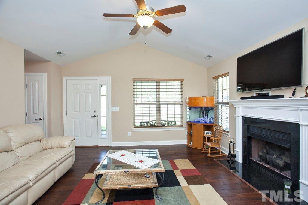 103 Orkney Road Stem, NC 27581 - Photo 2 of 25 a living room with furniture a flat screen tv and a fireplace