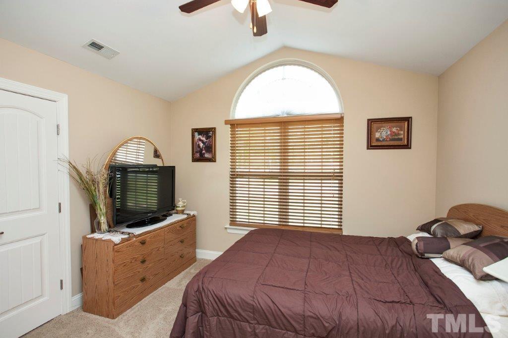 103 Orkney Road Stem, NC 27581 - Photo 19 of 25 a bedroom with a large bed and a flat tv screen on dresser