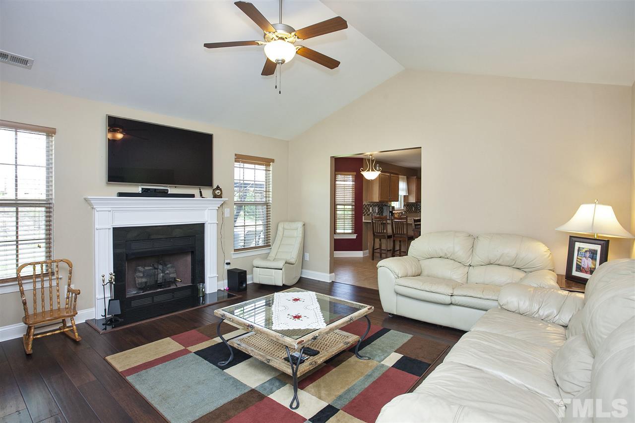 103 Orkney Road Stem, NC 27581 - Photo 3 of 25 a living room with furniture a flat screen tv and a fireplace