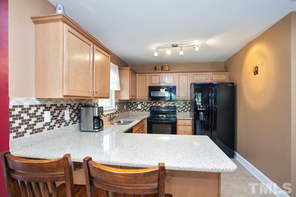 103 Orkney Road Stem, NC 27581 - Photo 4 of 25 a kitchen with stainless steel appliances granite countertop a refrigerator a sink a stove and island
