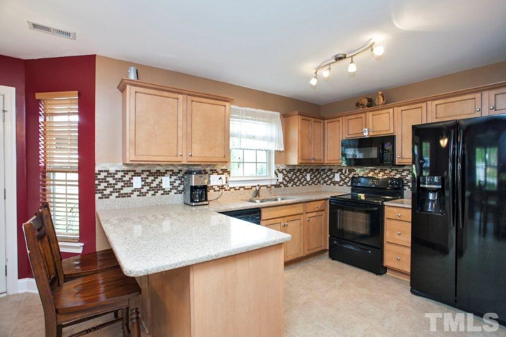 103 Orkney Road Stem, NC 27581 - Photo 6 of 25 a kitchen with stainless steel appliances microwave stove refrigerator sink and cabinets
