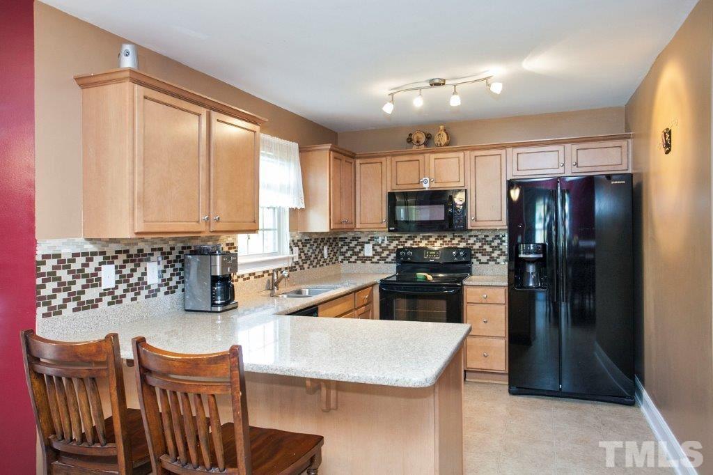 103 Orkney Road Stem, NC 27581 - Photo 7 of 25 a kitchen with stainless steel appliances granite countertop a refrigerator a stove top oven and a sink with wooden floor