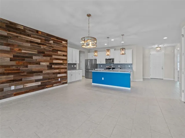 a view of kitchen with granite countertop cabinets and refrigerator