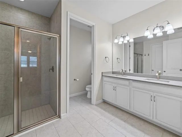a spacious bathroom with a shower sink and mirror