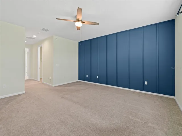 a view of an empty room with a ceiling fan