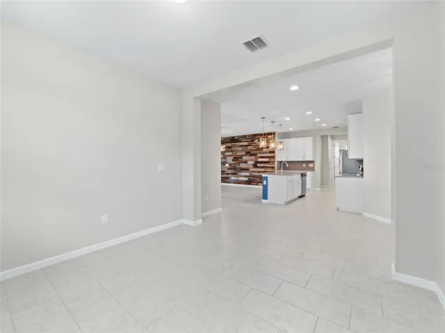 a view of a kitchen with refrigerator and chairs