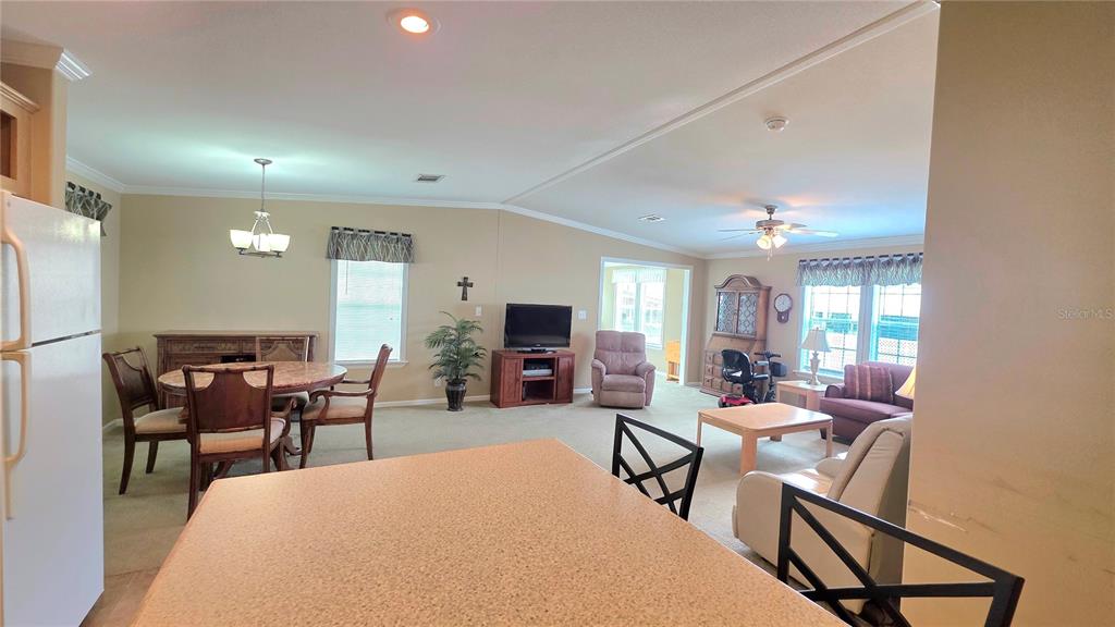 36740 Strand Drive Zephyrhills, FL 33542 - Photo 16 of 74 a living room with furniture a chandelier and a flat screen tv