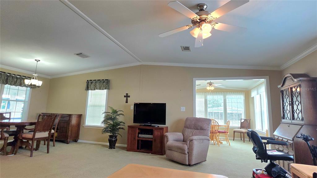 36740 Strand Drive Zephyrhills, FL 33542 - Photo 22 of 74 a living room with furniture ceiling fan and a flat screen tv