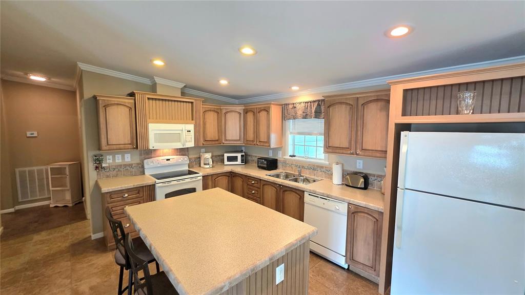 36740 Strand Drive Zephyrhills, FL 33542 - Photo 27 of 74 a kitchen with a refrigerator a stove and a dining table with wooden floor