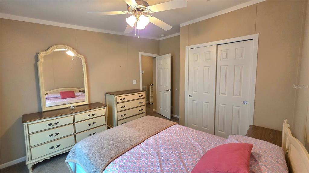 36740 Strand Drive Zephyrhills, FL 33542 - Photo 36 of 74 a bedroom with a bed and a chandelier