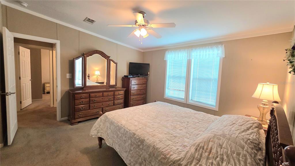 36740 Strand Drive Zephyrhills, FL 33542 - Photo 38 of 74 a bedroom with a bed and a chandelier