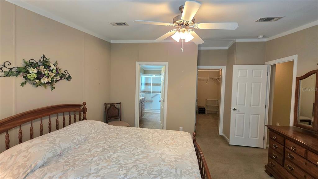 36740 Strand Drive Zephyrhills, FL 33542 - Photo 39 of 74 a bedroom with a bed and a chandelier
