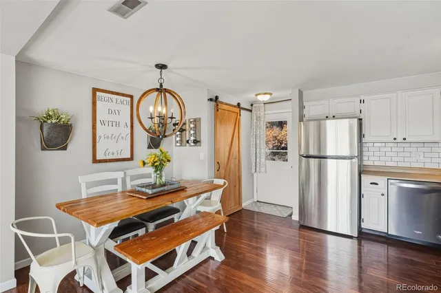 a kitchen with kitchen island a wooden floor and a refrigerator