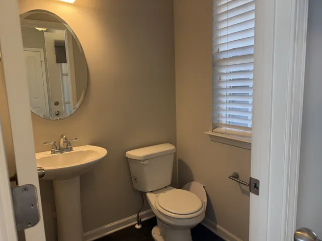 a bathroom with a toilet sink and mirror