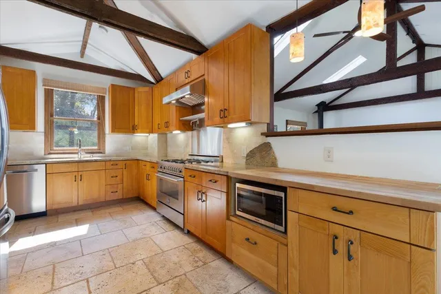 a kitchen with stainless steel appliances granite countertop a sink and white cabinets