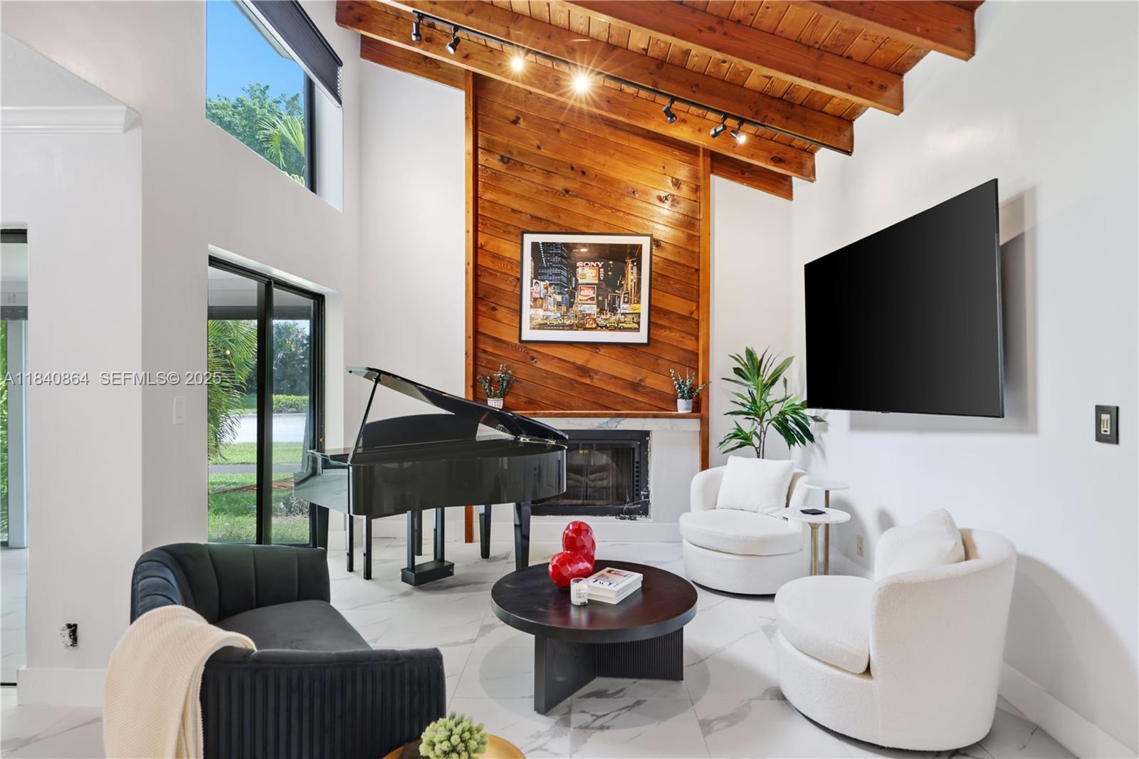 19654 Back 9 Drive Boca Raton, FL 33498 - Photo 2 of 35 a living room with furniture a flat screen tv and a floor to ceiling window