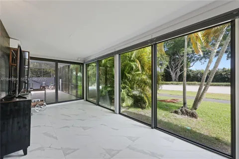 a view of an empty room with wooden floor and a floor to ceiling window