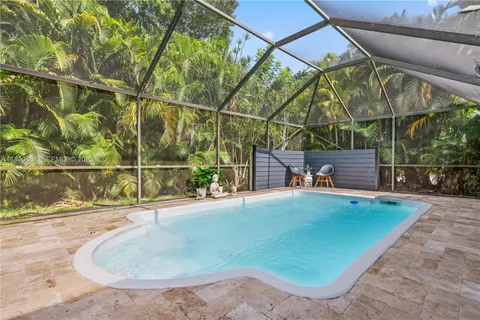 a view of a backyard with sitting area and swimming pool