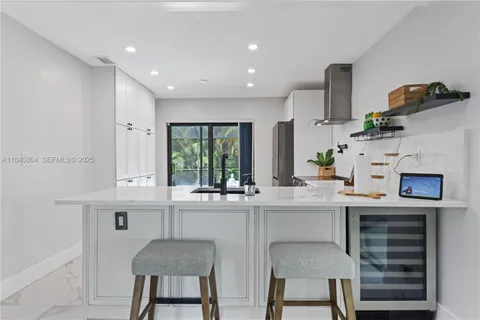 a kitchen with kitchen island a stove a table and chairs in it