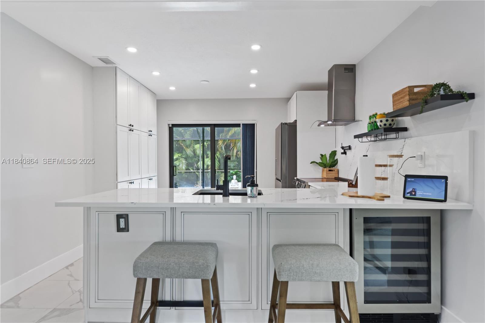 19654 Back 9 Drive Boca Raton, FL 33498 - Photo 8 of 35 a kitchen with kitchen island a stove a table and chairs in it