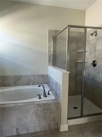 a bathroom with a tub sink and mirror