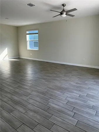 an empty room with a ceiling fan and carpet