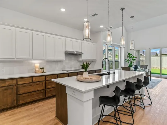 a kitchen with stainless steel appliances kitchen island a table and chairs in it