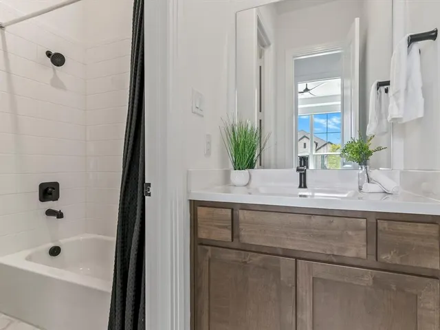 a bathroom with a tub sink and mirror