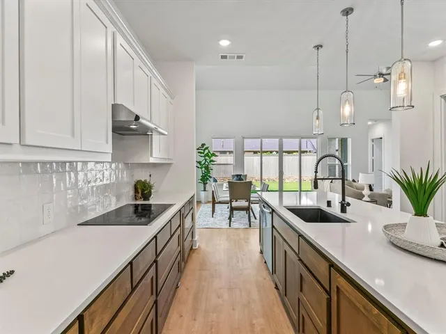 a kitchen with sink a stove and cabinets