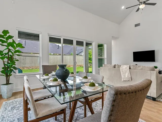 a living room with furniture a flat screen tv and a large window