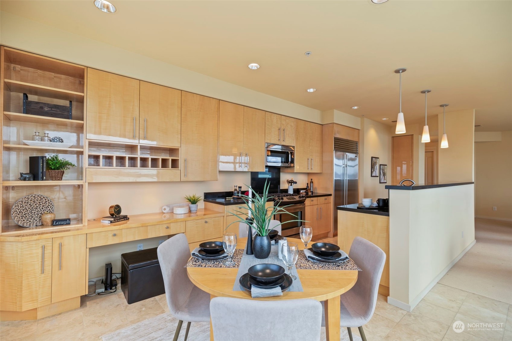 1900 Alaskan Way, Unit 516 Seattle, WA 98101 - Photo 12 of 40 a kitchen with stainless steel appliances kitchen island granite countertop a table and chairs