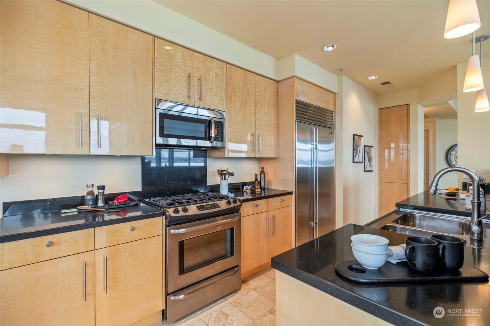 1900 Alaskan Way, Unit 516 Seattle, WA 98101 - Photo 14 of 40 a kitchen with stainless steel appliances granite countertop a sink stove and cabinets