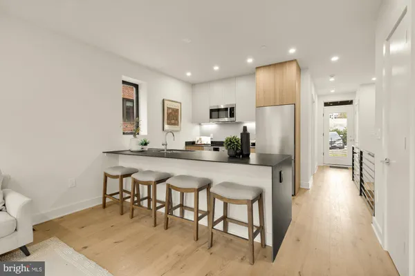 a kitchen with stainless steel appliances granite countertop a refrigerator and a stove top oven