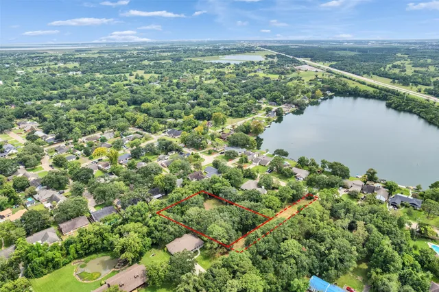 an aerial view of residential houses with outdoor space and lake view