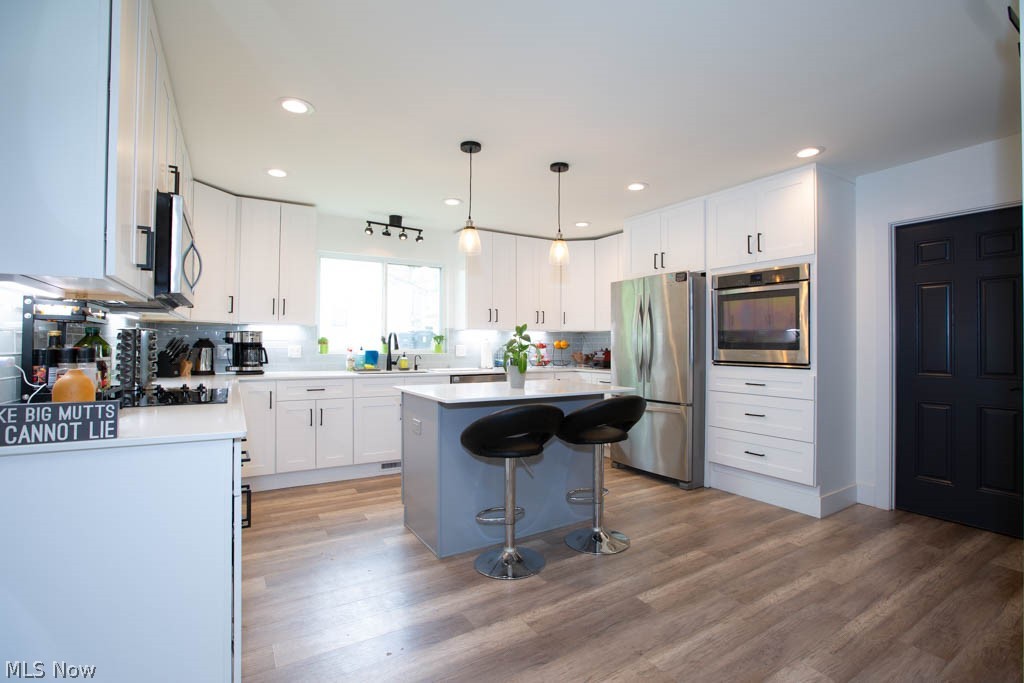 35240 Pettibone Road Solon, OH 44139 - Photo 2 of 35 Spacious eat-in kitchen w/quartz counters, island seating with high-end light fixtures, built-in microwave, built-in oven, cooktop range, dishwasher, all stainless steel.