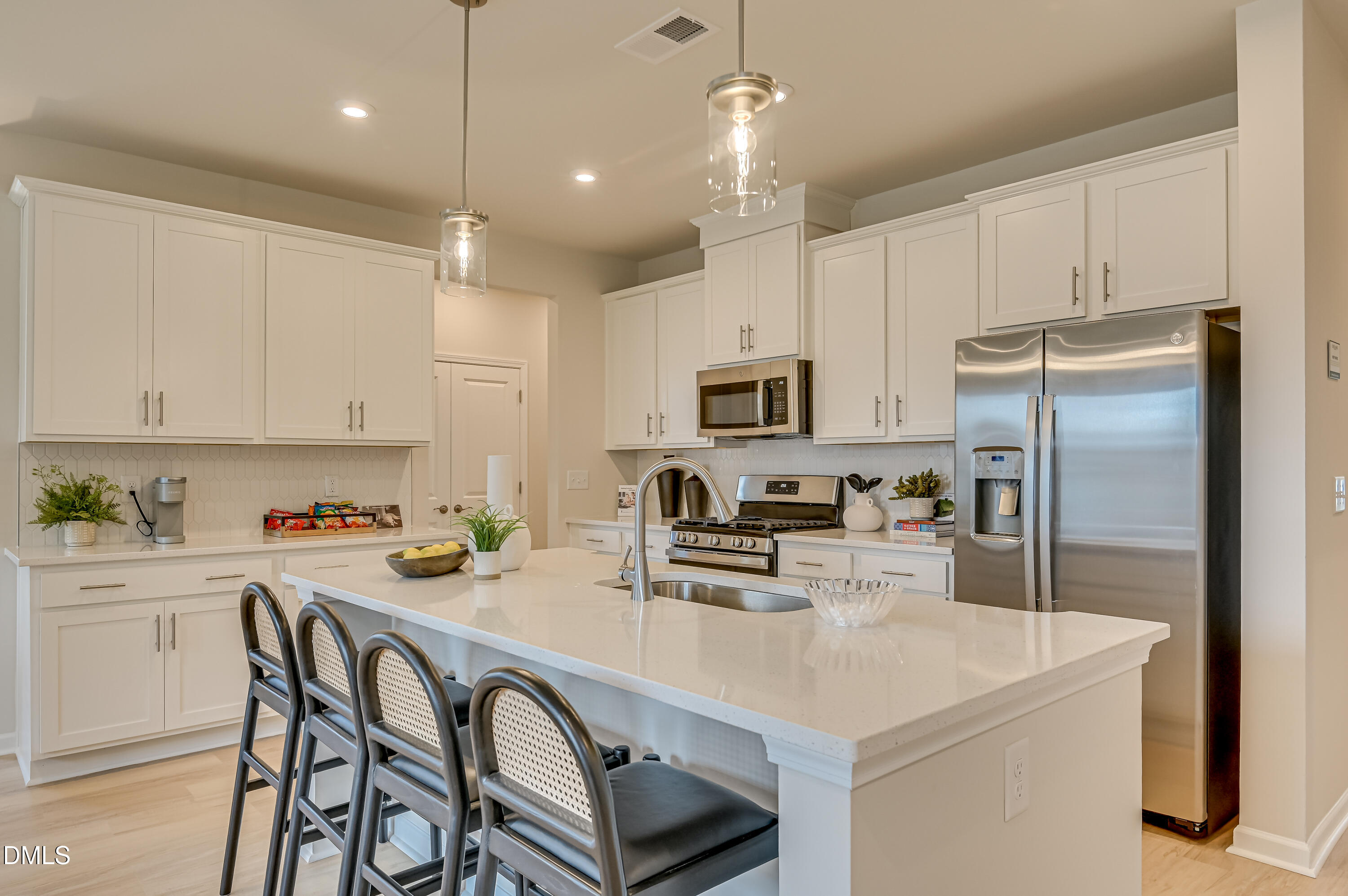 331 Jeter Grove Road Apex, NC 27523 - Photo 3 of 28 a kitchen with kitchen island a refrigerator stove microwave and cabinets