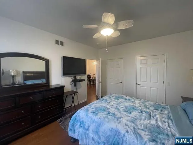 a bedroom with a bed and a flat tv screen on dresser