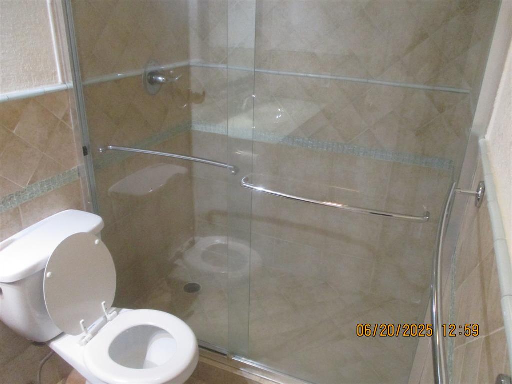 2651 South Course Drive, Unit 404 Pompano Beach, FL 33069 - Photo 21 of 40 a bathroom with a toilet and a shower
