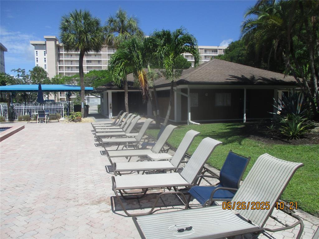 2651 South Course Drive, Unit 404 Pompano Beach, FL 33069 - Photo 40 of 40 a view of a patio with table and chairs potted plants and palm tree