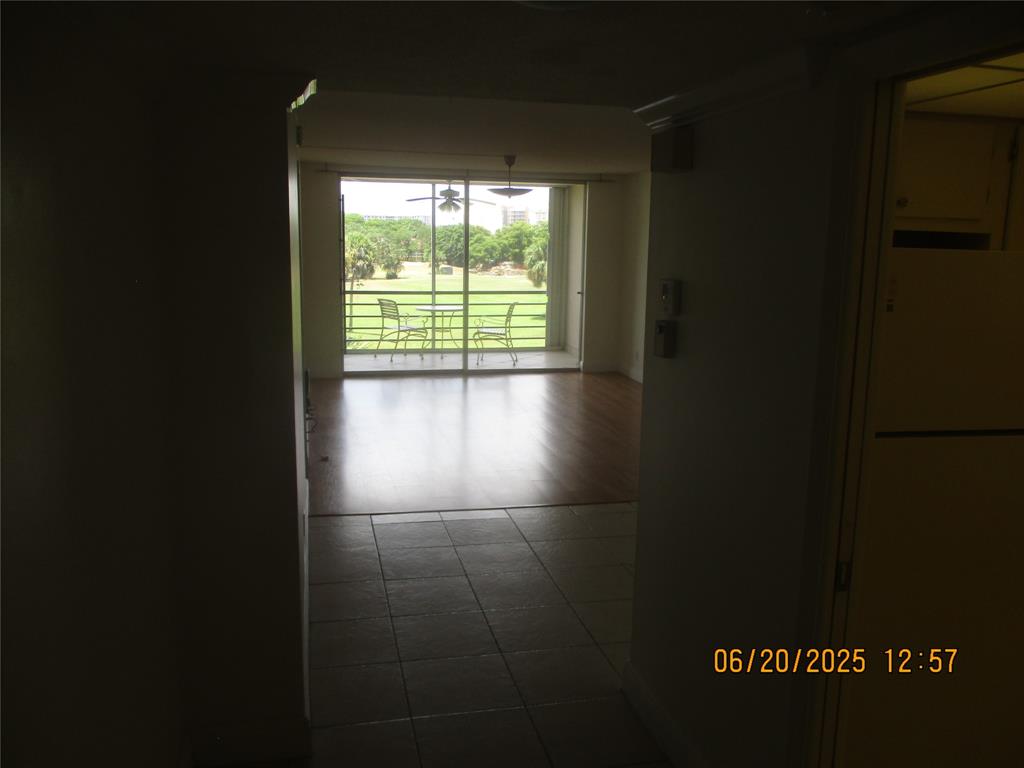 2651 South Course Drive, Unit 404 Pompano Beach, FL 33069 - Photo 5 of 40 a view of an empty room with wooden floor and a window