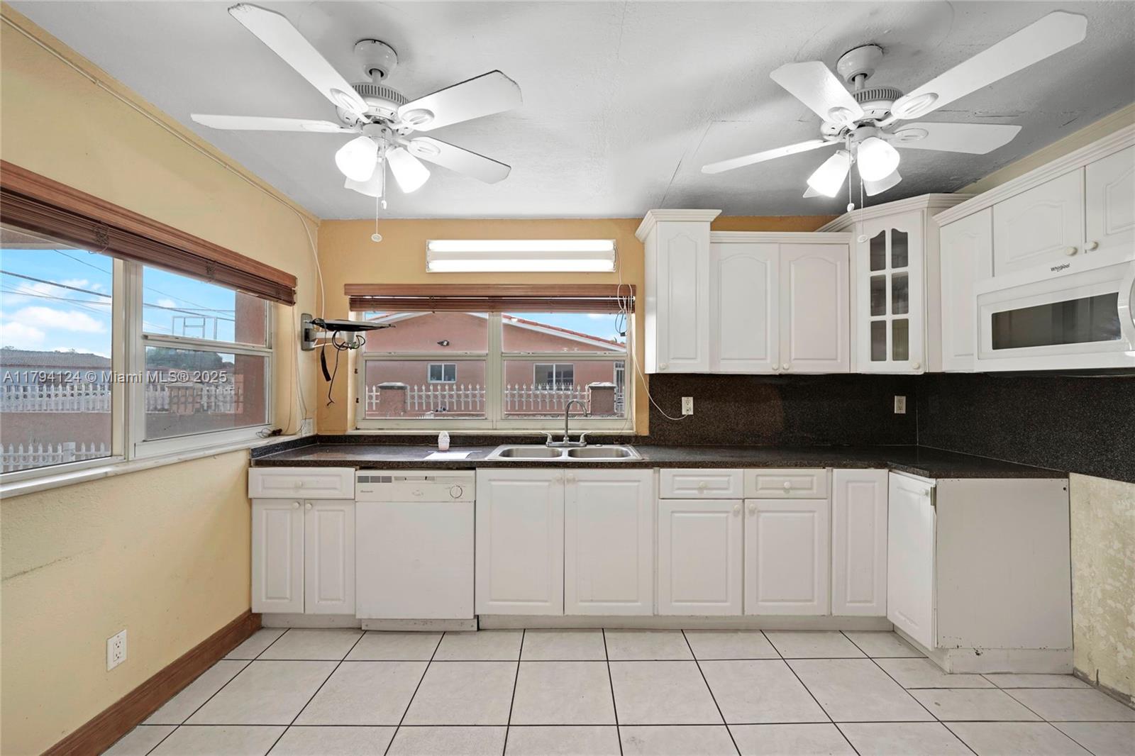 4241 West 1st Avenue Hialeah, FL 33012 - Photo 11 of 33 a kitchen with a sink a counter top space cabinets and stainless steel appliances