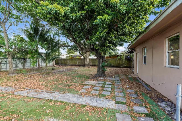 a backyard of a house with table and chairs